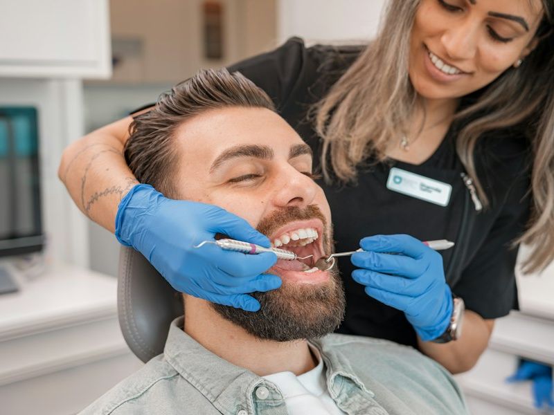 Dentist examining a smiling patient’s teeth